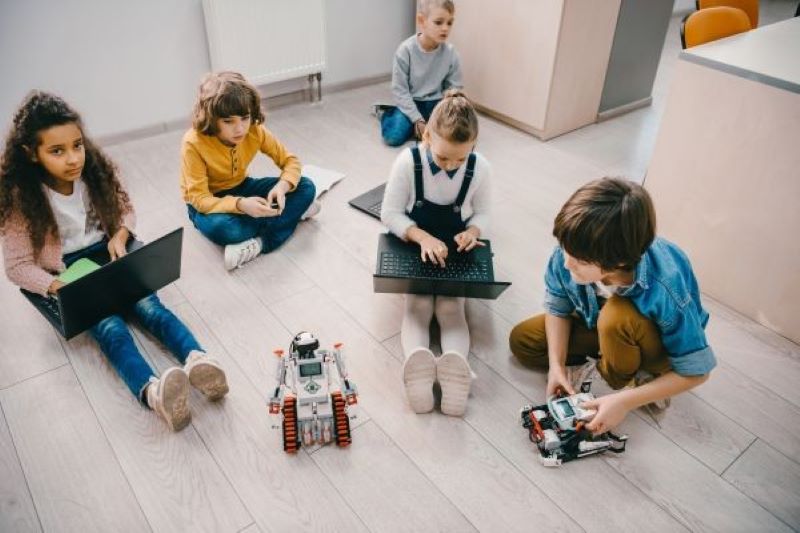 kids in a circle playing with a robot