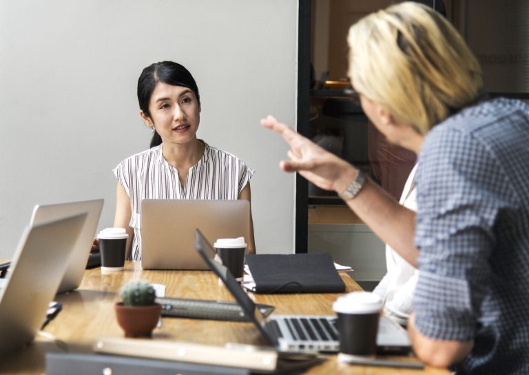 woman points at another woman